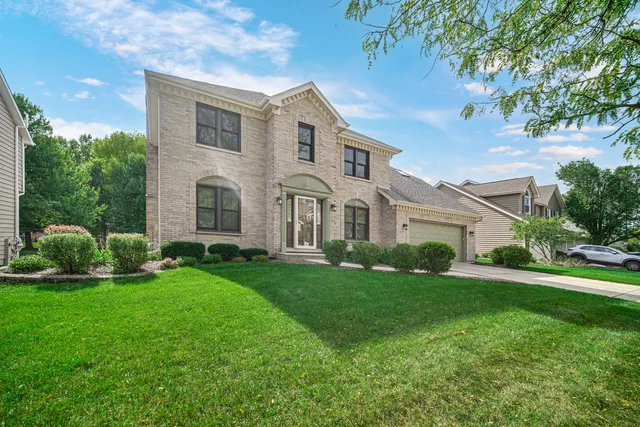 a view of a white house with a big yard and large trees