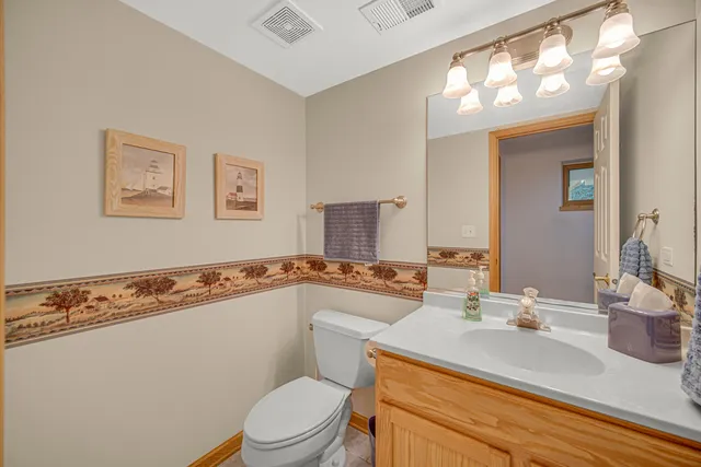 a bathroom with a granite countertop sink a toilet a mirror and bathtub