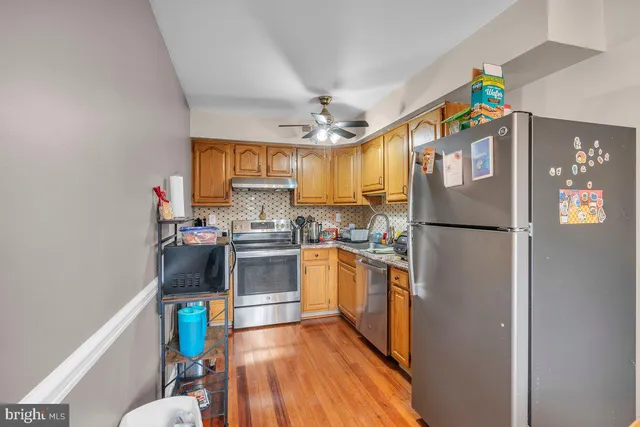 a kitchen with stainless steel appliances granite countertop a refrigerator and a stove top oven