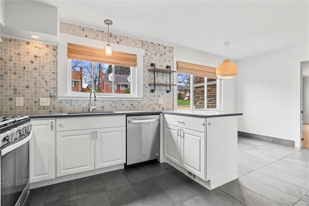 1110 10th Street Irwin, PA 15642 - Photo 5 of 50 a kitchen with granite countertop white cabinets and white appliances