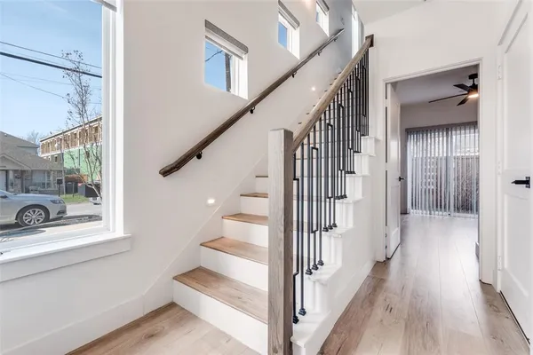 a view of a hallway with wooden floor and staircase