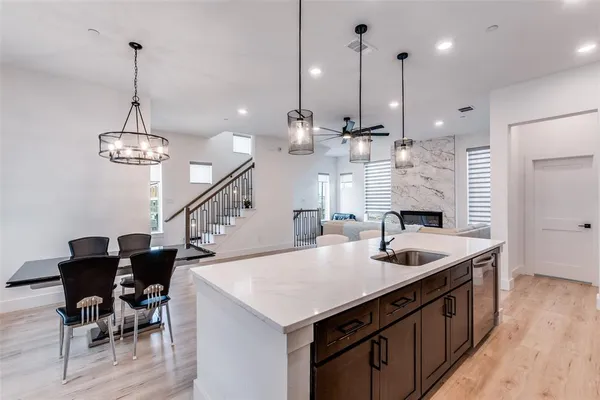 a kitchen with a stove a refrigerator a sink dishwasher with a dining table and chairs