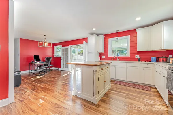 a view of a livingroom with furniture a chandelier and wooden floor