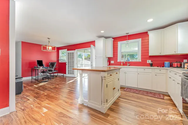 a view of a livingroom with furniture a chandelier and wooden floor