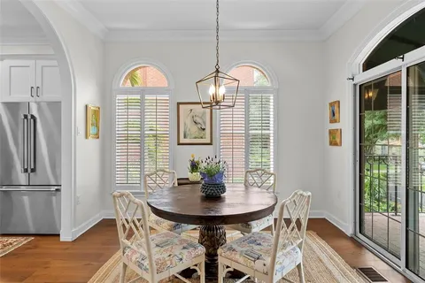a dining room with furniture potted plants and wooden floor