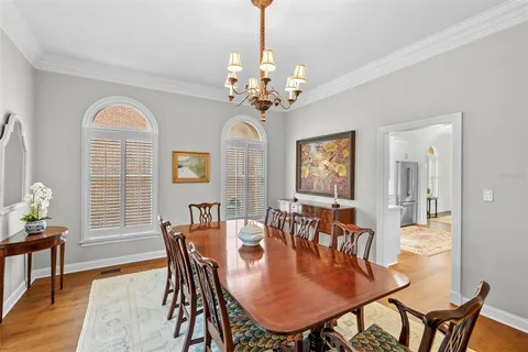 a dining room with furniture a chandelier and wooden floor