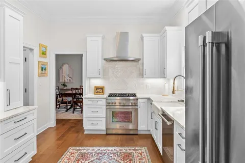 a living room with stainless steel appliances granite countertop furniture and a chandelier
