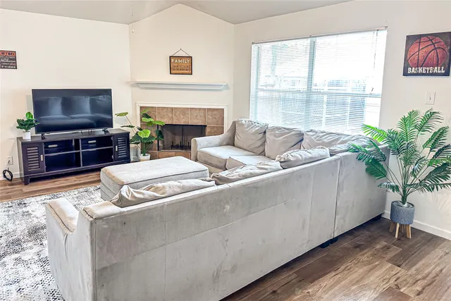 a living room with furniture a flat screen tv and a fireplace