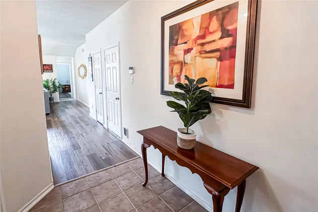a view of a hallway with wooden floor and a potted plant