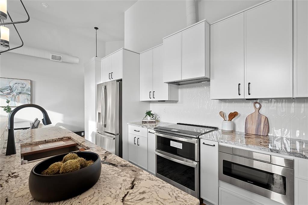 3080 Smallman Street Pittsburgh, PA 15201 - Photo 16 of 48 a kitchen with stainless steel appliances kitchen island granite countertop a stove a sink and a refrigerator