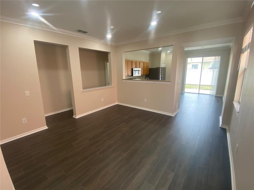 2409 Spring Hollow Loop Wesley Chapel, FL 33544 - Photo 4 of 47 an empty room with wooden floor and windows