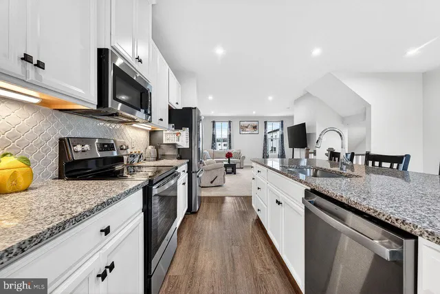 a large kitchen with stainless steel appliances granite countertop a lot of counter space