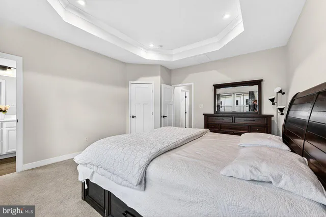 a bedroom with a large bed and wooden floor