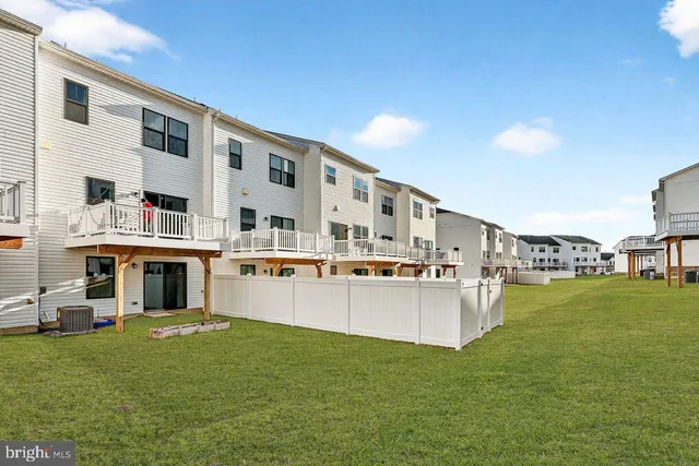 a large white building with a big yard and more windows
