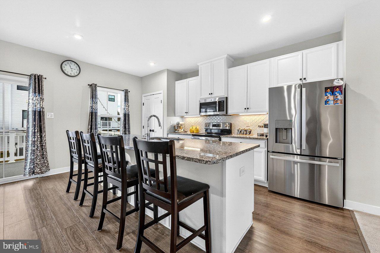 39 Sage Way Mount Laurel, NJ 08054 - Photo 7 of 32 a kitchen with stainless steel appliances granite countertop a dining table chairs refrigerator and microwave