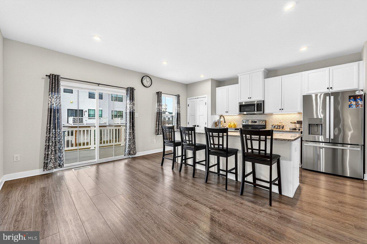 39 Sage Way Mount Laurel, NJ 08054 - Photo 9 of 32 a kitchen with stainless steel appliances a dining table chairs refrigerator and cabinets