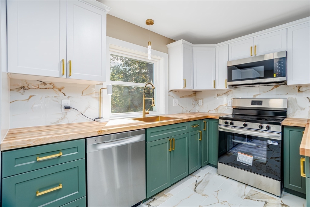 7 Groveland Street Ayer, MA 01432 - Photo 26 of 35 a kitchen with cabinets a window and stainless steel appliances