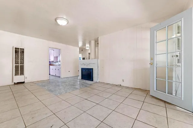a view of a livingroom with an empty space and a kitchen