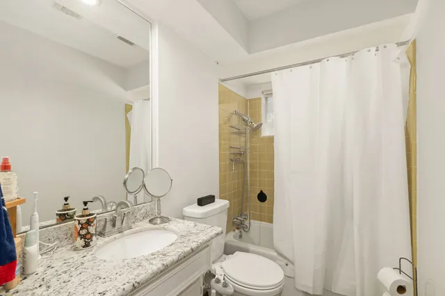 a bathroom with a granite countertop sink toilet and shower