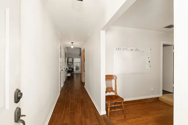 a view of a hallway with wooden floor and closet
