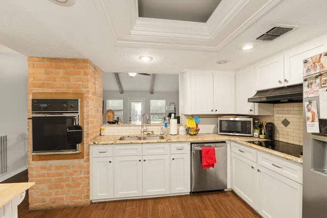 a kitchen with granite countertop a sink stainless steel appliances and cabinets