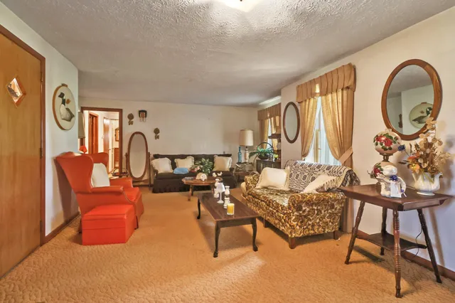 a living room with furniture a large window and a chandelier