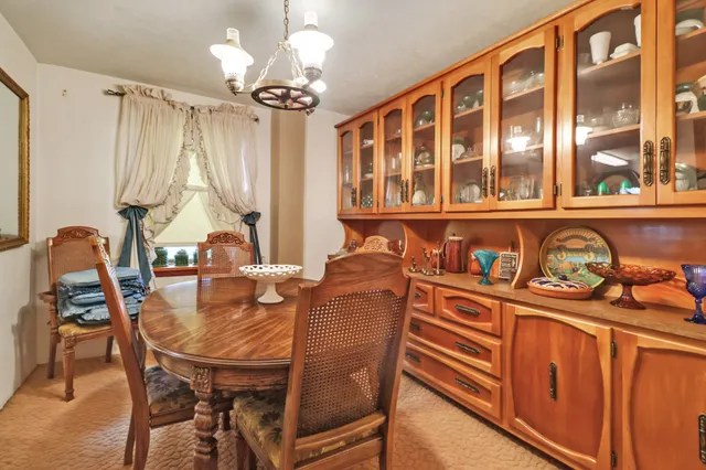 a dining room with furniture a chandelier and wooden floor