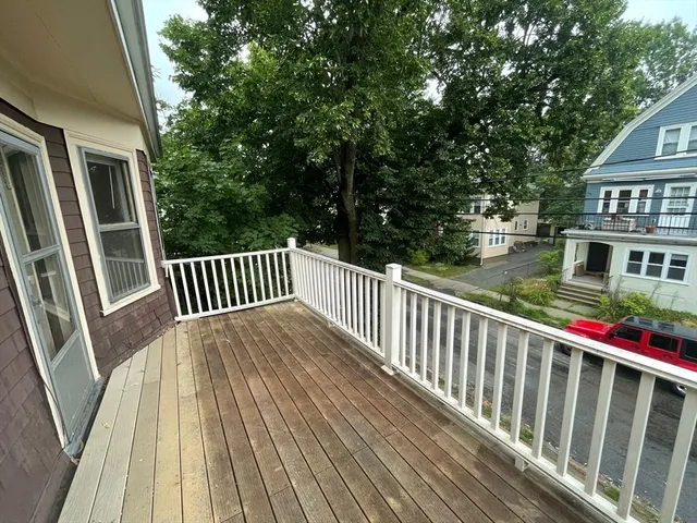 a view of a wooden deck and a yard with swimming pool