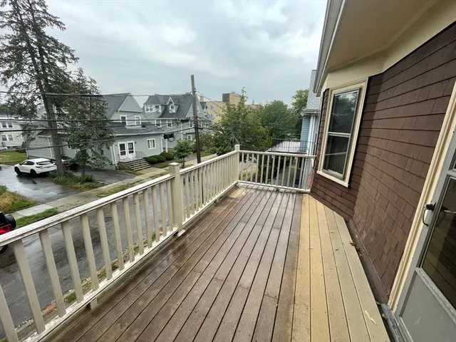 a view of balcony with wooden floor and fence