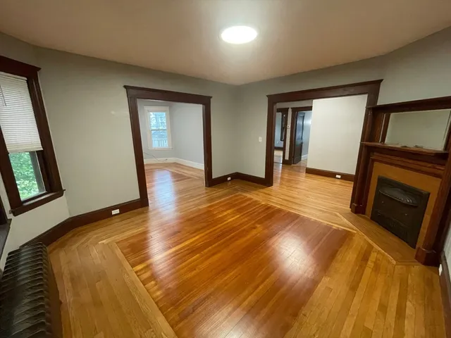 a view of empty room with wooden floor