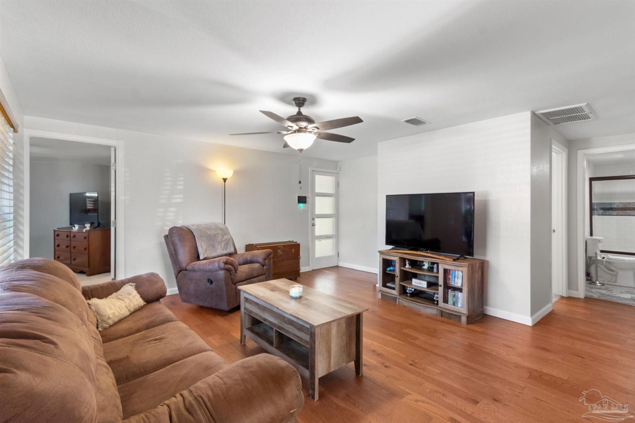 6608 Magnolia Street Milton, FL 32570 - Photo 14 of 36 a living room with furniture and a flat screen tv