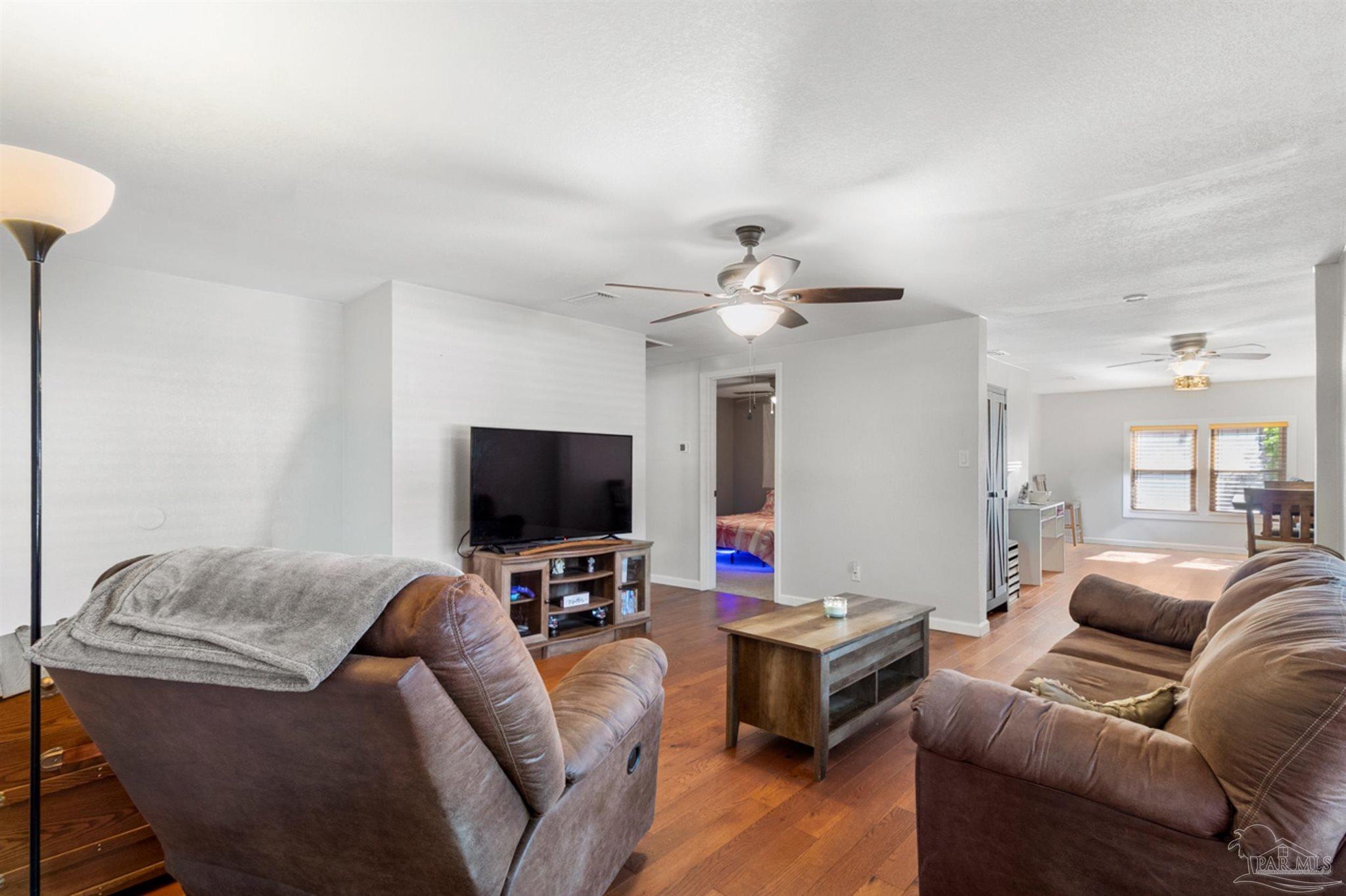 6608 Magnolia Street Milton, FL 32570 - Photo 15 of 36 a living room with furniture and a flat screen tv