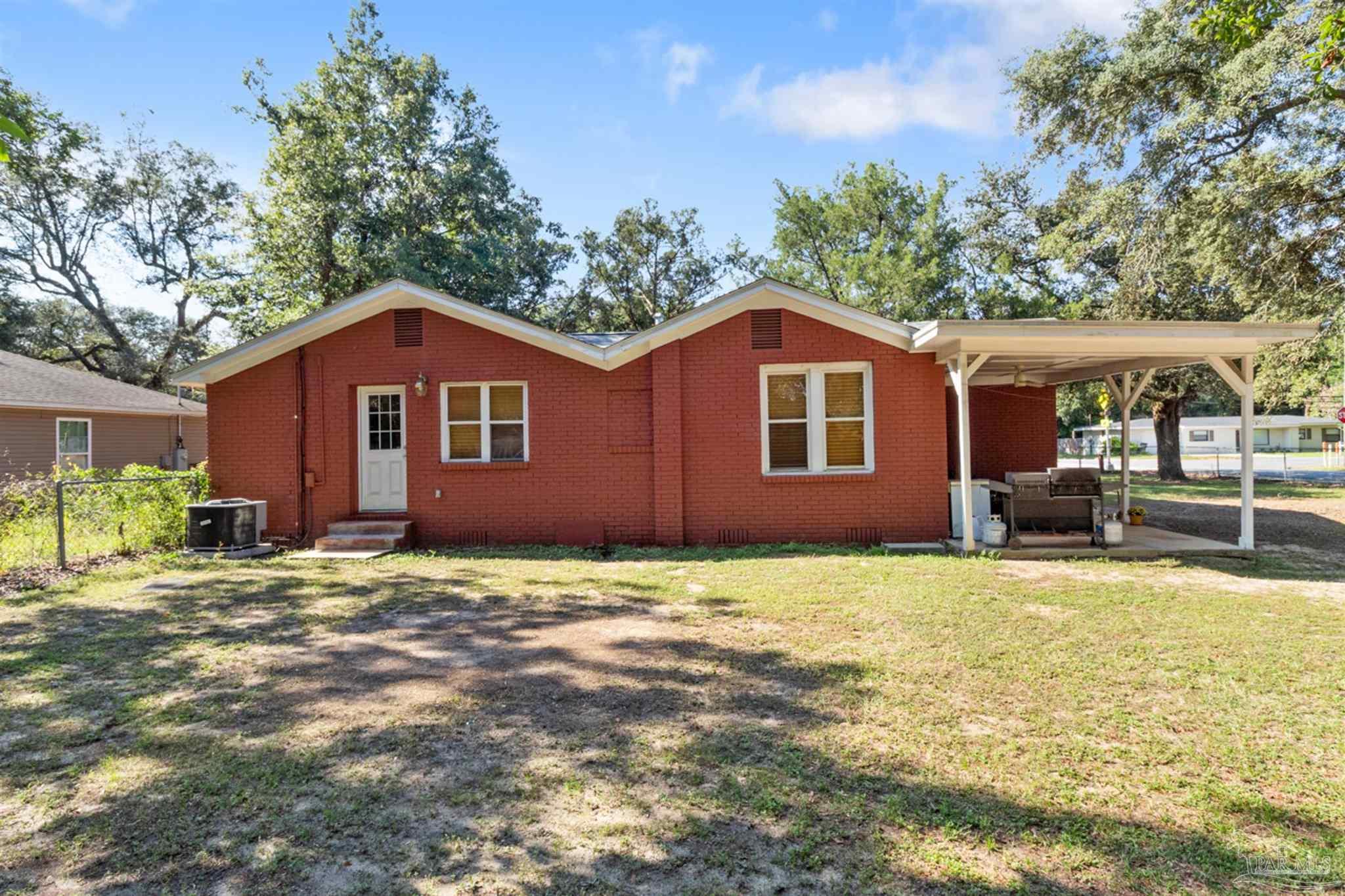 6608 Magnolia Street Milton, FL 32570 - Photo 28 of 36 a big house with a big yard and large trees