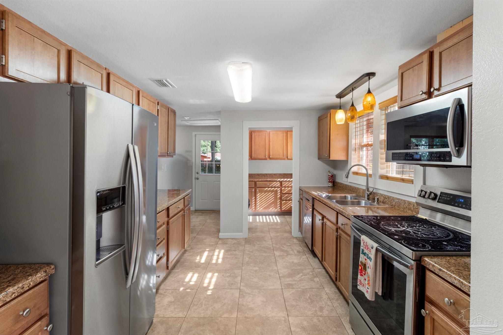 6608 Magnolia Street Milton, FL 32570 - Photo 3 of 36 a kitchen with stainless steel appliances granite countertop a refrigerator stove and oven