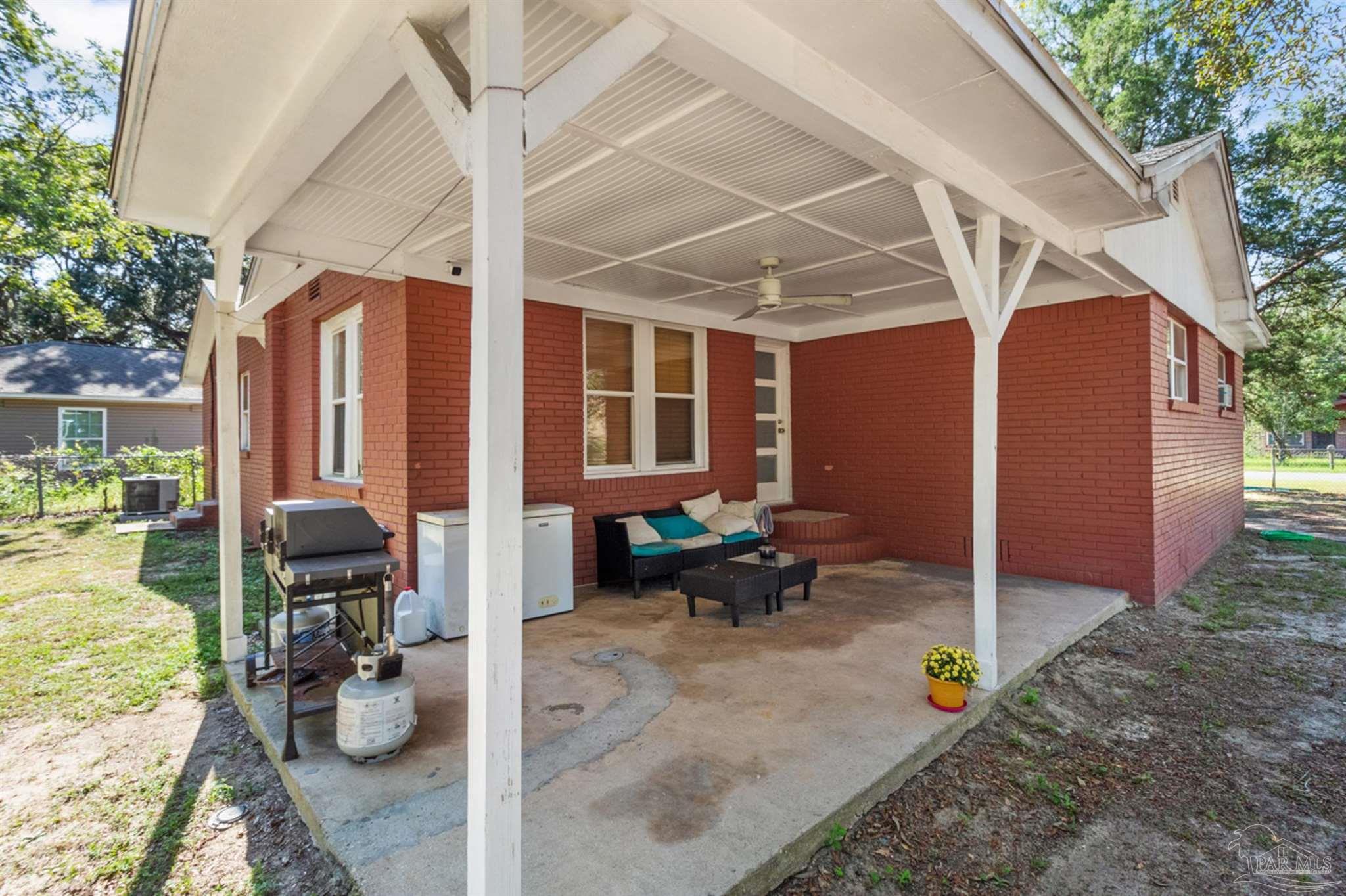 6608 Magnolia Street Milton, FL 32570 - Photo 31 of 36 a view of a patio with table and chairs potted plants and a large tree