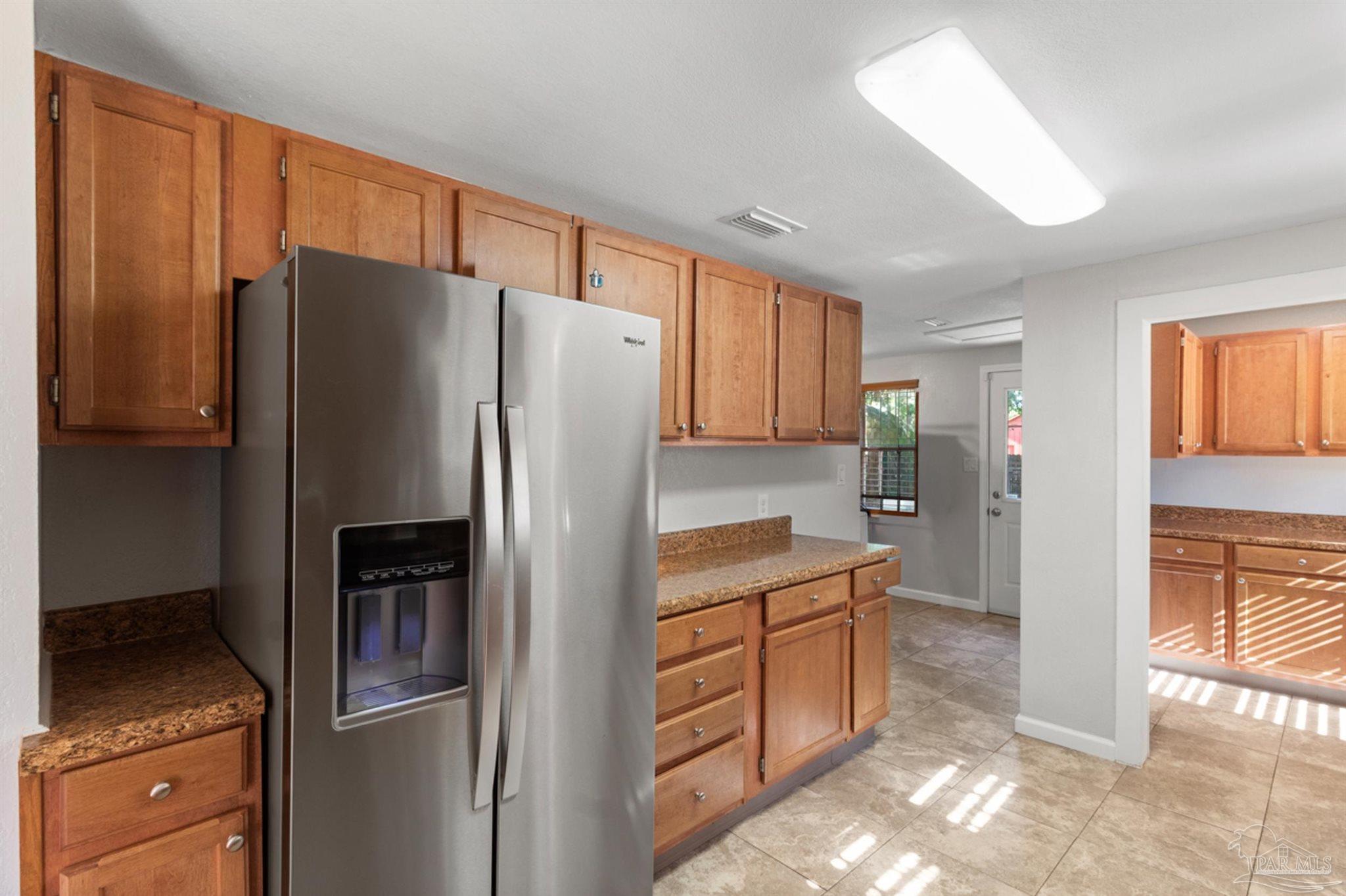 6608 Magnolia Street Milton, FL 32570 - Photo 5 of 36 a kitchen with stainless steel appliances granite countertop a refrigerator and a stove top oven