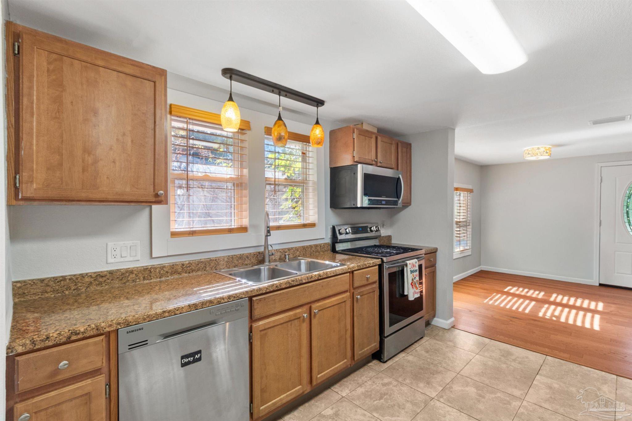 6608 Magnolia Street Milton, FL 32570 - Photo 8 of 36 a kitchen with stainless steel appliances granite countertop a sink stove and microwave