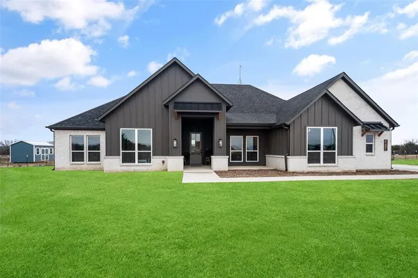 a front view of a house with a garden and patio