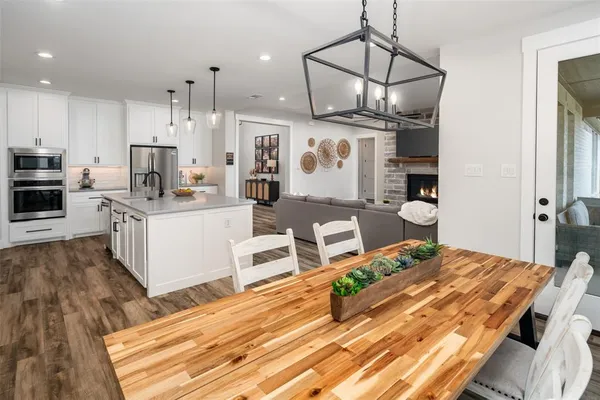 a open kitchen with stainless steel appliances granite countertop a stove and a wooden floors