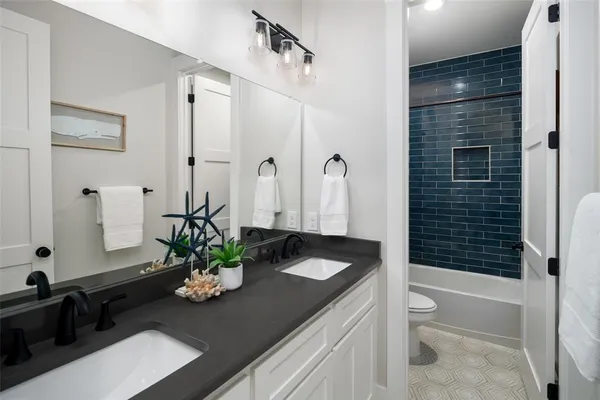 a bath room with a sink a toilet and shower