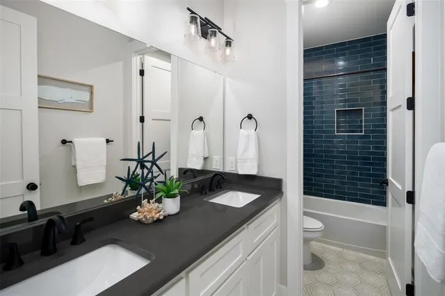 a bath room with a sink a toilet and shower