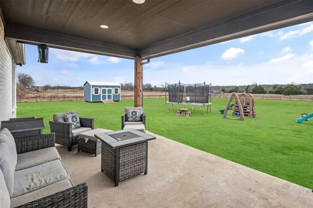 a view of a patio with couches chairs and a yard