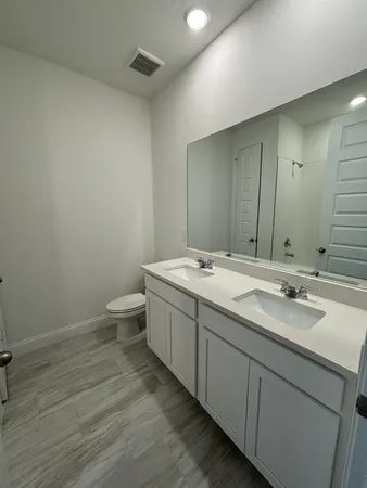 a bathroom with a double vanity sink and mirror
