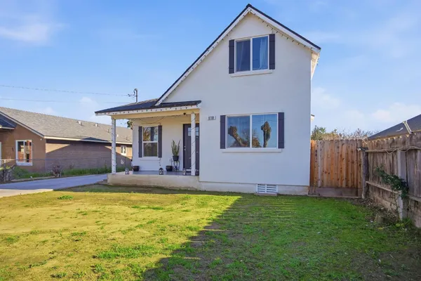 a view of a house with backyard and sitting area
