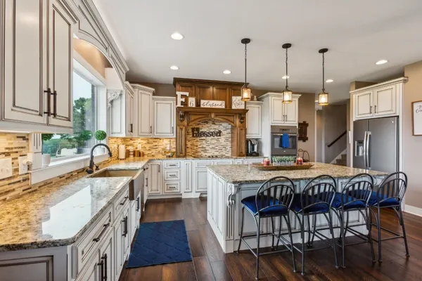 a large kitchen with a table chairs and a wooden floor