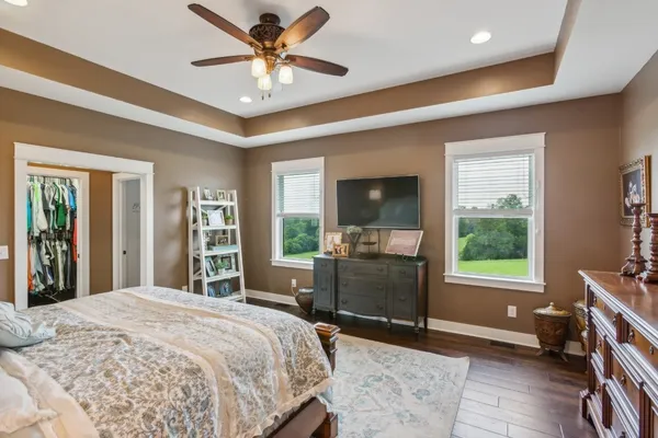 a bedroom with a bed and a large window with chair
