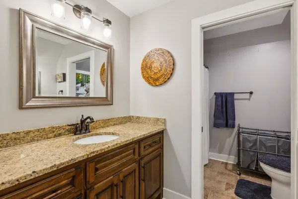 a bathroom with a granite countertop sink and a mirror