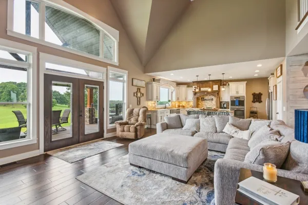 a living room with furniture floor to ceiling window and wooden floor