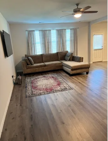 a living room with furniture and a wooden floor