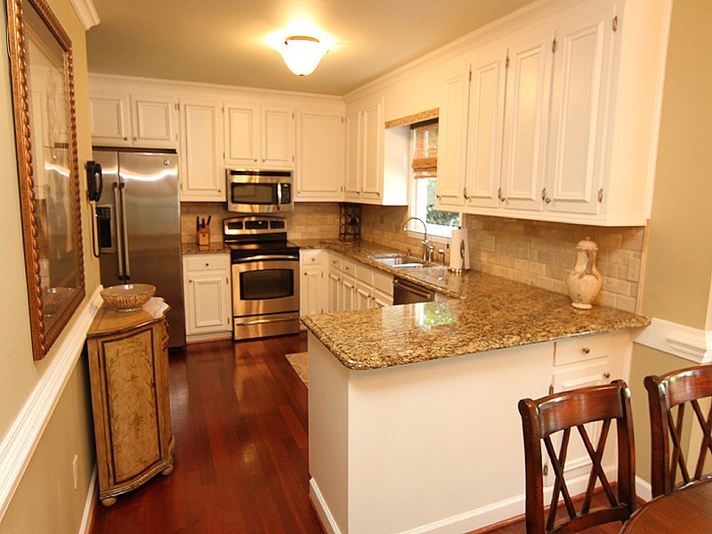 2712 Farnborough Road Raleigh, NC 27613 - Photo 5 of 25 Remodeled Kitchen features white painted cabinets, SS appliances and granite counter tops. 2 pantry/storage closets and breakfast room with bay window overlooking private backyard. Kitchen